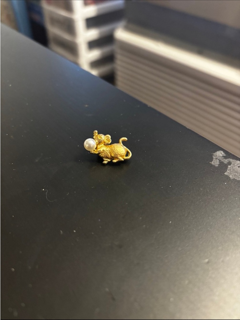 mouse holding a pearl brooch pin